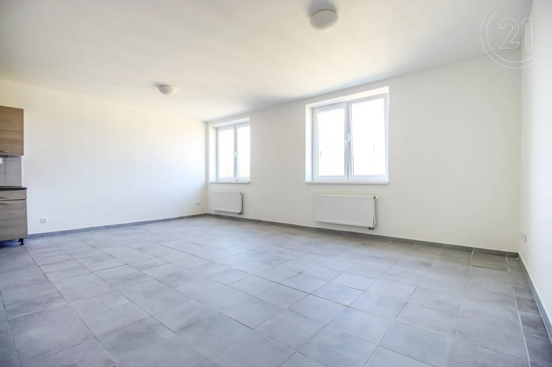 prázdná místnost s radiátor, kachličková podlaha, a přirozené světlo