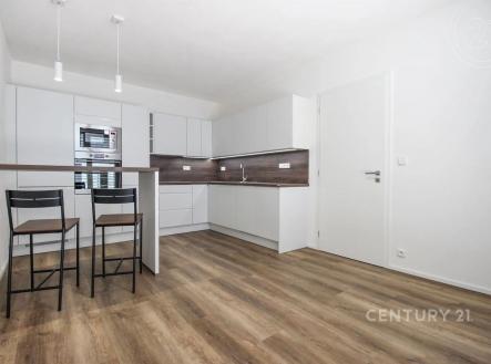 kuchyně s backsplash, ploché panelové skříňky, mikrovlnná trouba, dřevěná podlaha, a bílé skříně | Pronájem bytu, 2+kk, 46 m²