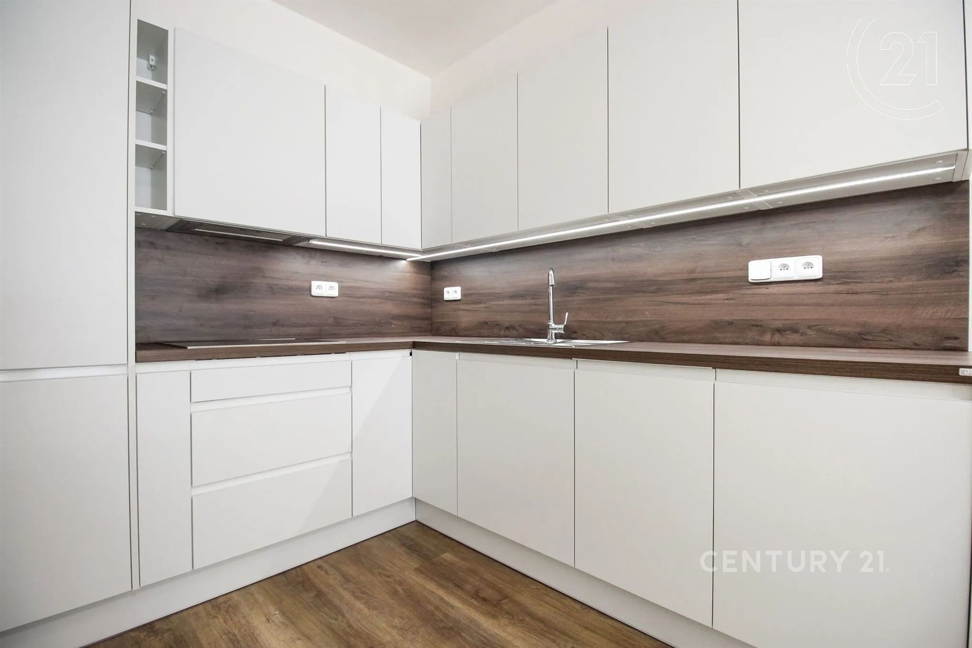 kuchyně s ploché panelové skříňky, dřevěná podlaha, bílé skříně, a backsplash