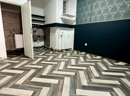 Moderní kuchyň s parketovou podlahou ve vzoru, stylové tapety a klasické radiátory, ideální pro rekonstrukci. | Pronájem - obchodní prostor, 35 m²