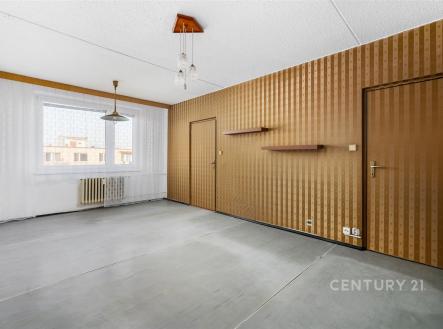 Prázdný obývací pokoj s betonovou podlahou, dřevěné panely, velké okno, minimalistický design, světlý prostor, připraven k rekonstrukci | Prodej bytu, 3+1, 75 m²