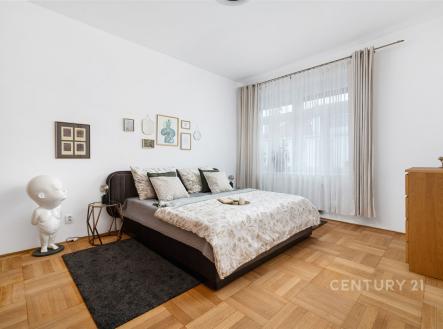 Prostorná ložnice s parketovou podlahou, velká okna zajišťující světlé prostředí, moderní nábytek, elegantní dekorace na stěnách. | Prodej bytu, 4+1, 146 m²