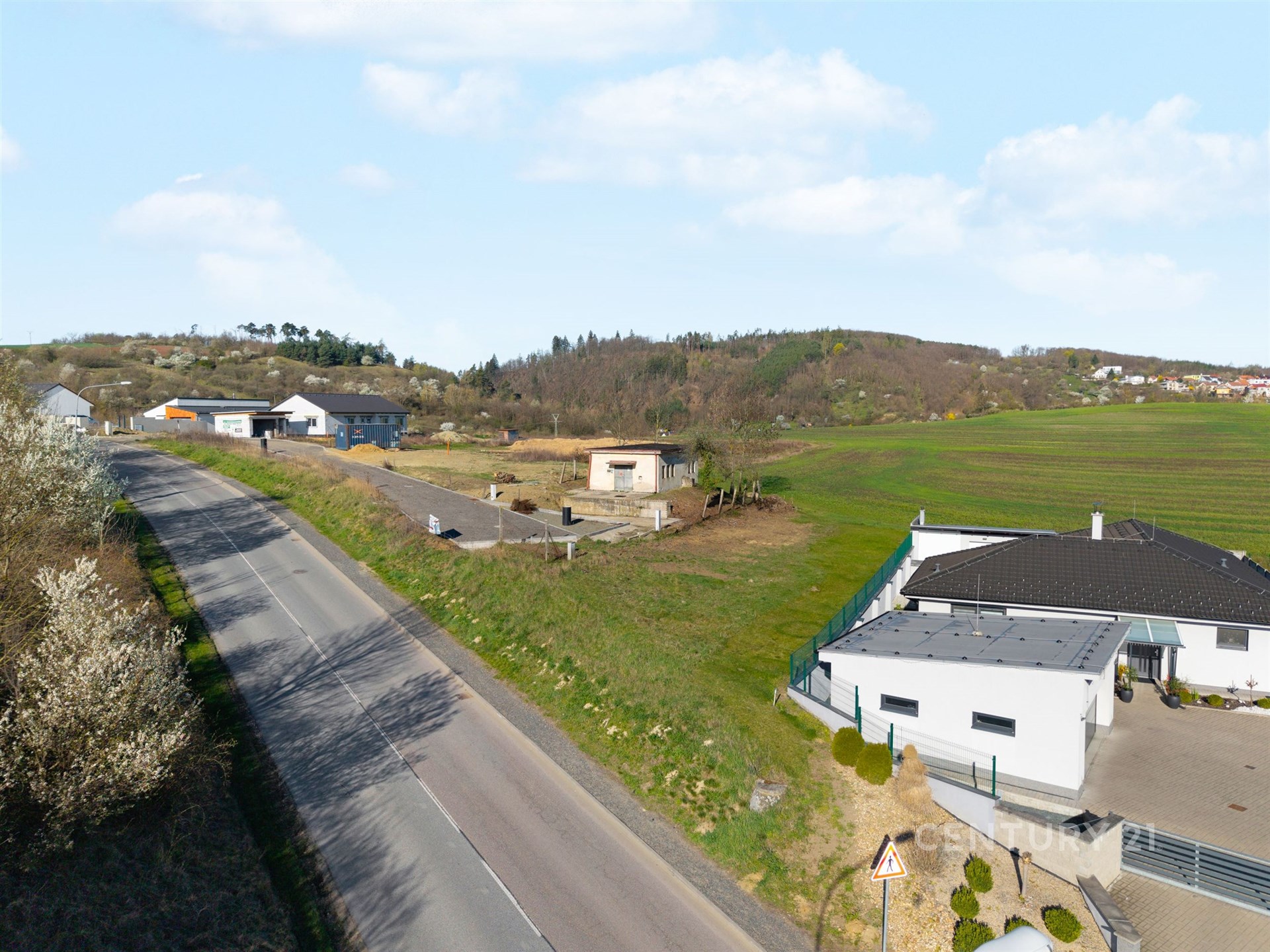 Novostavba rodinného domu s moderními prvky, nacházející se u klidné silnice na okraji vesnice, obklopená přírodou a panoramatickým výhledem.
