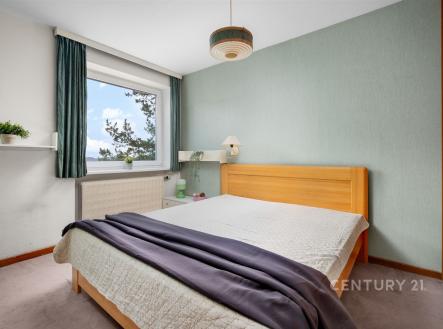 Světlá ložnice s parketovou podlahou, velkým oknem a vestavěnými skříněmi, moderní design a příjemná atmosféra pro relaxaci. | Prodej bytu, 2+kk, 46 m²