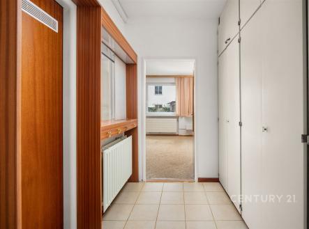 Vstupní chodba se světlou dlažbou a vestavěnými skříněmi, dřevěné obložení, vede do světlého obývacího pokoje, moderní styl. | Prodej bytu, 2+kk, 46 m²