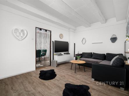 Světlý obývací pokoj s moderním nábytkem, parketovou podlahou a dekorativními prvky. Velká pohovka nabízí komfortní posezení. | Prodej bytu, 4+1, 98 m²