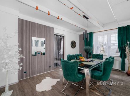 Jídelna s moderním designem, luxusní zelené čalounění, tmavá dřevěná podlaha, velká okna se závěsy, elegantní osvětlení, světlý interiér. | Prodej bytu, 4+1, 98 m²