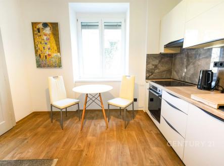 Kuchyň s moderním nábytkem, parketová podlaha, světlý prostor, kachlová zástěna a velké okno poskytují přirozené světlo | Pronájem bytu, 2+1, 72 m²