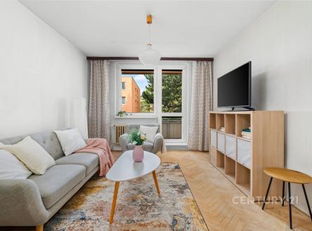 Světlý obývací pokoj s parketovou podlahou, velká okna nabízejí přírodní světlo, moderní nábytek v minimalistickém stylu. | Prodej bytu, 2+1, 51 m²