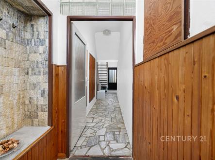Úzká vstupní chodba s dřevěným obložením a kamennou dlažbou, moderní design, světlé stěny, skleněné dveře vedoucí do další místnosti. | Prodej - dům/vila, 84 m²