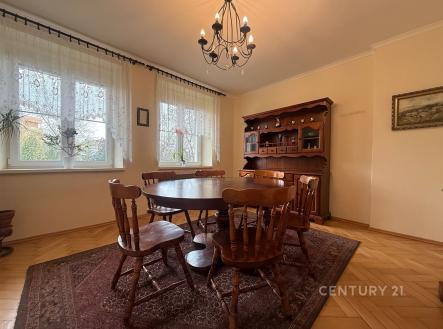 Jídelna s parketovou podlahou, dřevěným nábytkem a velkými okny, která propouštějí dostatek světla, vytváří útulný prostor pro rodinné stolování. | Prodej bytu, 5+1, 110 m²