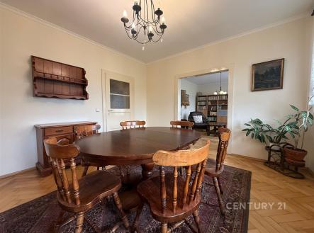 Jídelna s parketovou podlahou, dřevěným nábytkem a světlými stěnami, doplněná vestavěnými skříněmi a klasickým lustrem. | Prodej bytu, 5+1, 110 m²