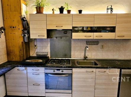 Moderní kuchyň s dřevěnými skříňkami, tmavou pracovní deskou a vestavěnou myčkou. Světlý prostor s rustikálním nádechem a praktickým uspořádáním. | Prodej bytu, 3+1, 80 m²