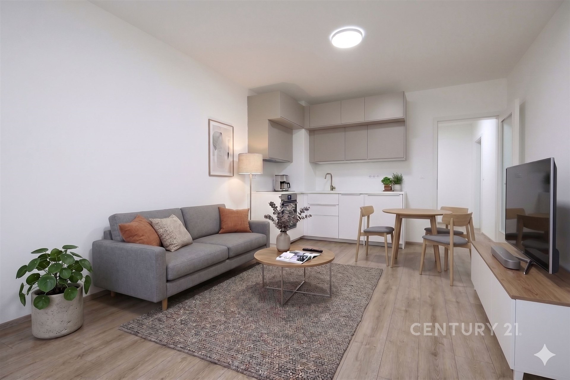 Světlý obývací pokoj s moderní kuchyní, parketová podlaha, světlý nábytek, otevřený prostor, příjemná atmosféra.