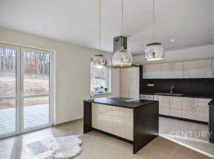 Moderní kuchyň s keramickou dlažbou, velká okna zajišťují dostatek světla, elegantní závěsná svítidla dominují prostoru. | Prodej - dům/vila, 320 m²