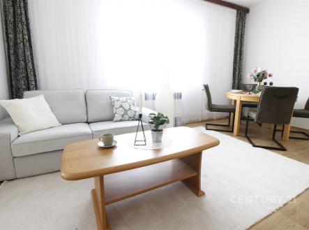 Světlý obývací pokoj s parketovou podlahou, velkými okny a moderním nábytkem. | Prodej - dům/vila, 124 m²