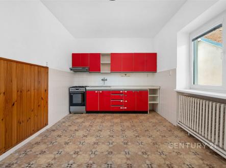 Kuchyň s dlažbou, moderní červené skříňky, prostorná dispozice, velké okno, dobré světlo, vhodná pro renovaci. | Prodej - dům/vila, 160 m²