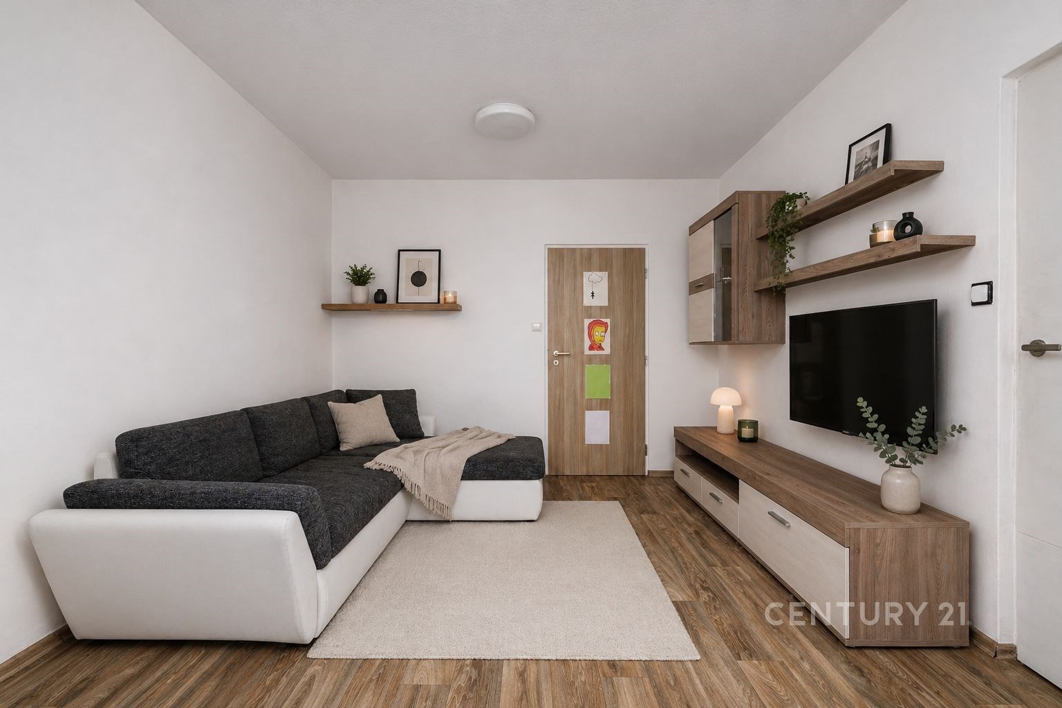 Světlý obývací pokoj s parketovou podlahou, moderní sedací soupravou a dřevěným nábytkem, minimalistický styl s dekorativními prvky.