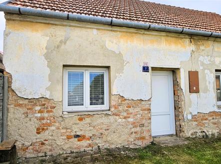 Exteriér staršího rodinného domu s fasádou v původním stavu, cihlovými detaily a šikmou střechou; ideální k rekonstrukci. | Prodej - dům/vila, 68 m²