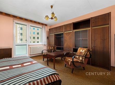 Prostorná ložnice s dřevěným nábytkem, vestavěné skříně a balkon. Kobercová podlaha, retro styl, ideální pro rekonstrukci. | Prodej bytu, 1+1, 43 m²