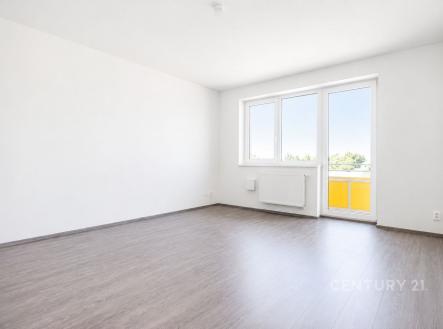 Světlý obývací pokoj s moderní parketovou podlahou a velkými okny, bílými stěnami a balkonem. | Prodej bytu, 3+kk, 74 m²