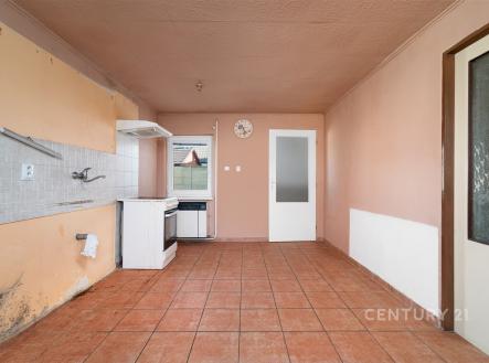 Kuchyň s dlažbou, k rekonstrukci, se staršími spotřebiči a velkými okny, prostorná s možností modernizace, příprava na vestavěné skříně. | Prodej - dům/vila, 90 m²