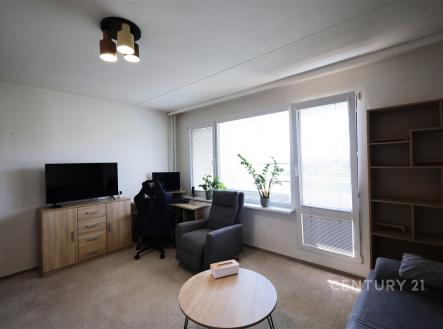 Světlý obývací pokoj s velkými okny, moderním nábytkem a světlým kobercem, ideální pro relaxaci nebo práci z domova. | Pronájem bytu, 2+kk, 42 m²