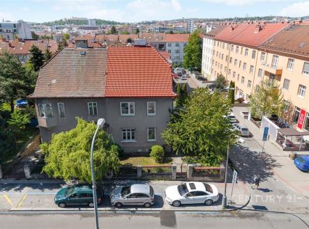 Prázdný venkovní prostor s rodinným domem, červenou střechou a zahradou, obklopený městskou infrastrukturou. | Prodej - dům/vila, 64 m²