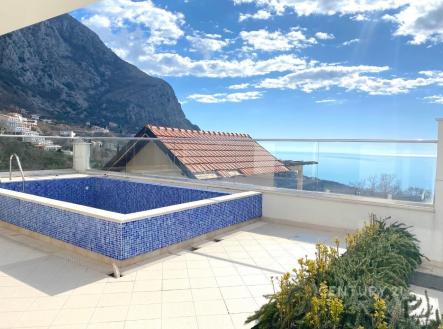 Střešní terasa s dlažbou a bazénem, nabízí úchvatný výhled na hory a moře, ideální pro relaxaci v moderním stylu. | Prodej - dům/vila, 150 m²