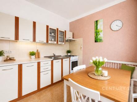 Moderní kuchyň s dlažbou, vestavěnými skříněmi a světlým jídelním koutem, ideální pro rodinné posezení. | Prodej bytu, 1+1, 40 m²