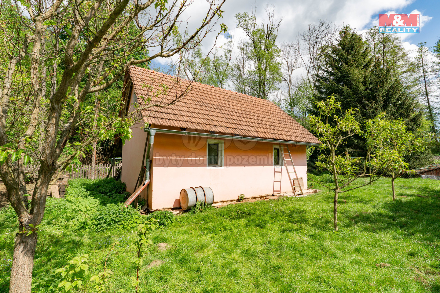 Zděný domek na pozemku.