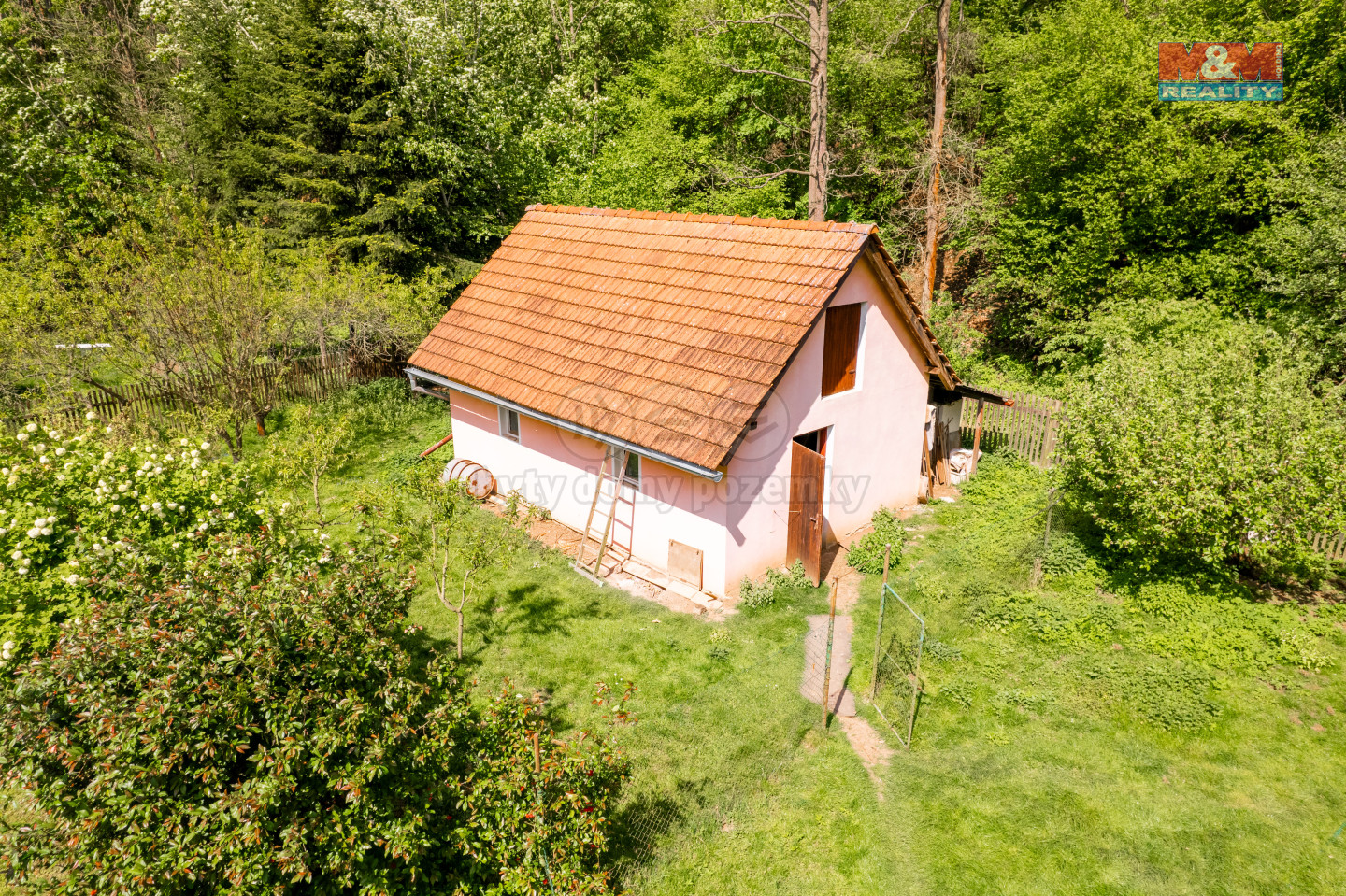 Zděný domek na pozemku.