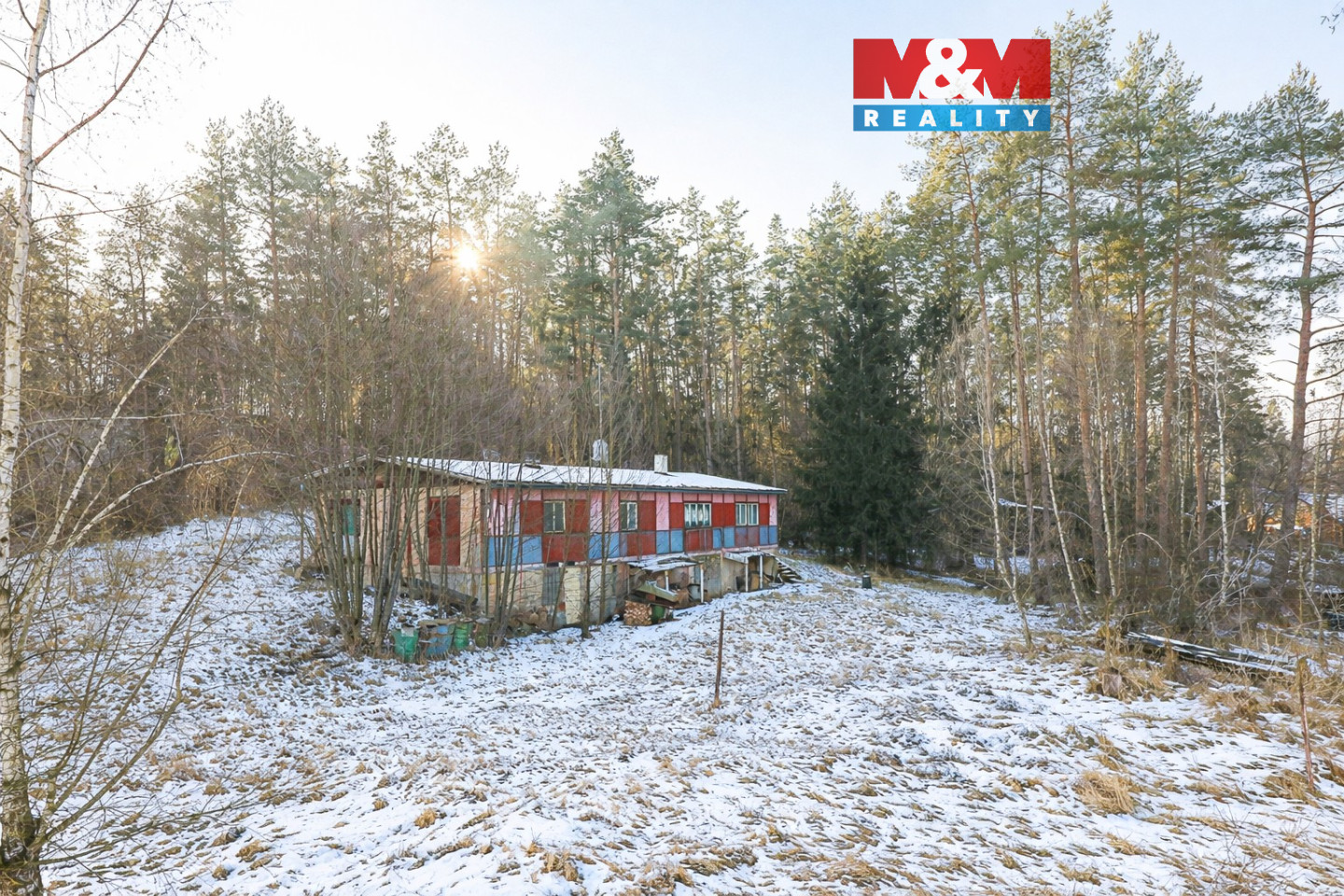 Sněhem pokrytá chata v lesích.jpg