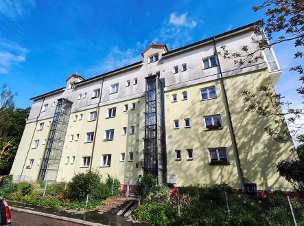 Exteriér bytového domu se světlou fasádou, velká okna a klidná rezidenční lokalita, moderní architektonické prvky, dobrý stav budovy. | Pronájem bytu, 2+1, 56 m²