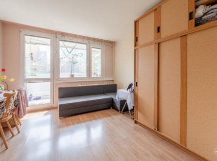 Světlý obývací pokoj s parketovou podlahou, velká okna s výhledem do zeleně a vstupem na balkon | Prodej bytu, 4+1, 85 m²