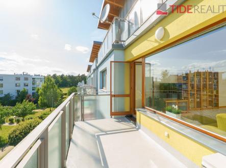 Prostorný balkon s moderním zábradlím, velká okna poskytující výhled na zeleň, světlá fasáda, ideální pro relaxaci. | Prodej bytu, 4+kk, 155 m²