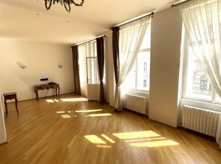 Světlý obývací pokoj s parketovou podlahou, velká okna s dlouhými závěsy, historický lustr, renovovaný interiér stylového bytu | Pronájem bytu, 3+kk, 108 m²