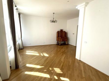 Světlý obývací pokoj s parketovou podlahou, velkými okny a elegantním lustrem, v moderním a čistém designu. | Pronájem bytu, 3+kk, 108 m²