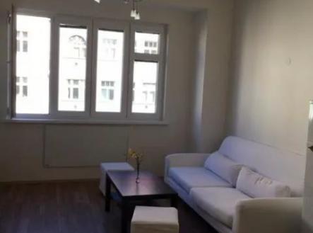obývací pokoj s pozoruhodný lustr, dřevěná podlaha, a přirozené světlo | Prodej bytu, 2+kk, 50 m²