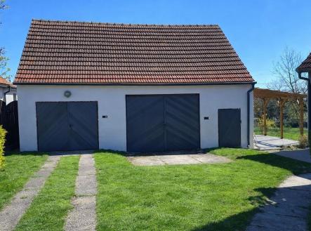 Praktická garáž s dvojitými vraty, příjezdová cesta s dlážděným povrchem, vedlejší prostor pro zastřešené parkování, dobře udržovaná zahrada. | Prodej - dům/vila, 330 m²