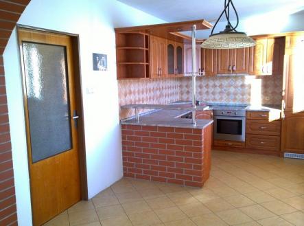 Kuchyň spojená s jídelnou, cihlový pult, dřevěné skříňky, dlažba na podlaze, světlý interiér, rustikální styl. | Prodej - dům/vila, 290 m²