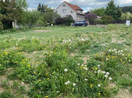 Stavební pozemek s rovinatým terénem obklopený zelení a květinami, ideální pro stavbu rodinného domu, klidná rezidenční lokalita. | Prodej - pozemek pro bydlení, 865 m²