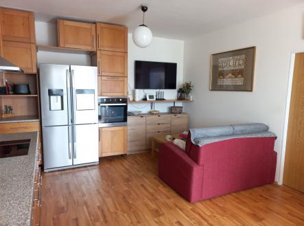 Kuchyň s obývacím prostorem, parketová podlaha, moderní skříňky, vestavěné spotřebiče, světlý interiér, prostorná lednice, pohodlná sedačka. | Prodej bytu, 3+kk, 73 m²