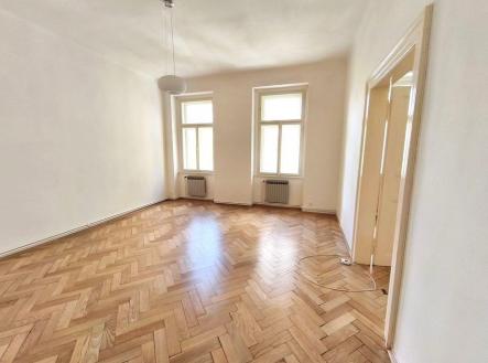 Světlý obývací pokoj s parketovou podlahou, velká okna poskytující dostatek přirozeného světla, čisté bílé stěny v moderním stylu. | Pronájem bytu, 3+1, 107 m²