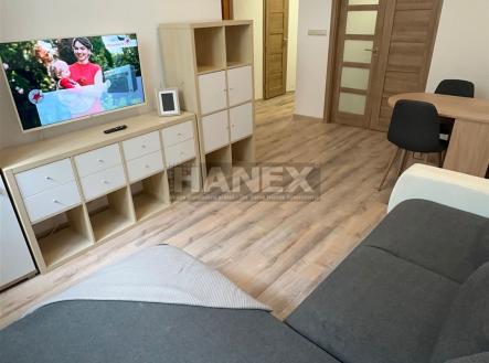 Světlý obývací pokoj s moderním nábytkem, parketovou podlahou a velkými dveřmi, vytváří příjemný a útulný prostor pro relaxaci. | Prodej bytu, 2+1, 47 m²