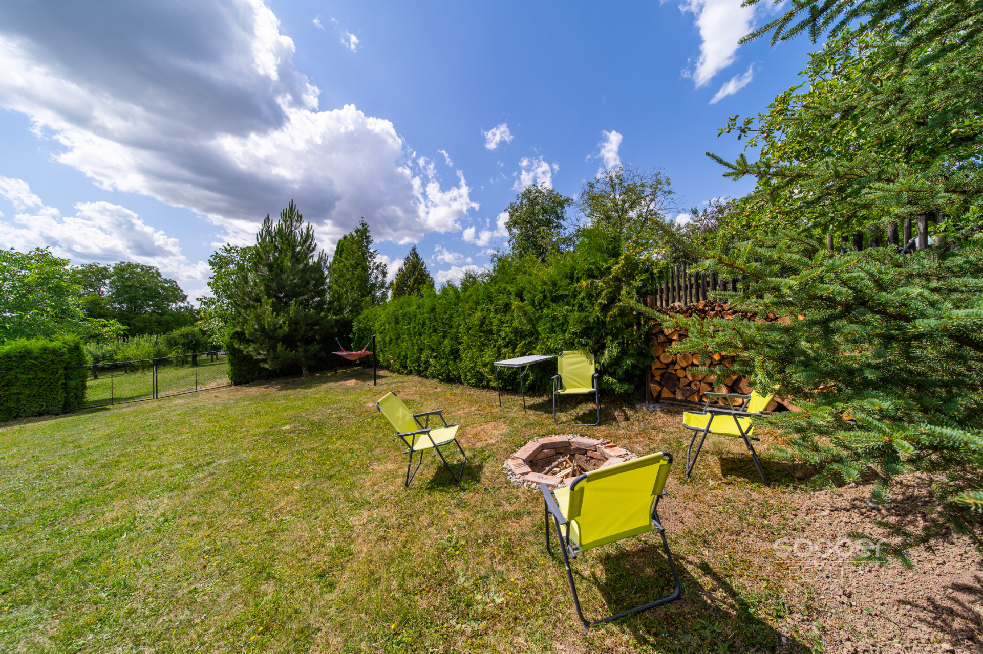 Příjemná venkovská zahrada s rekreačním karavanem a terasou.