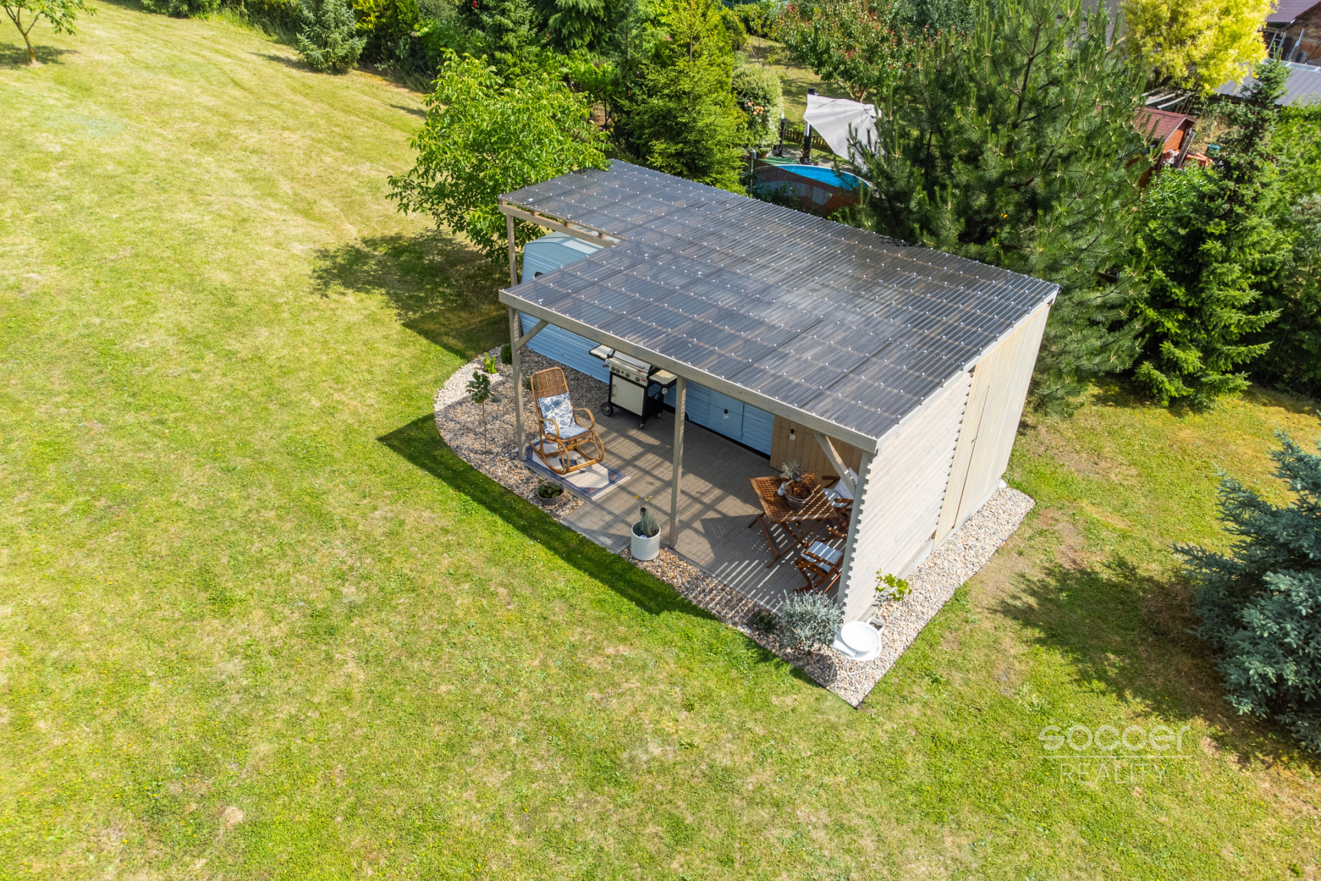 Příjemná venkovská zahrada s rekreačním karavanem a terasou.