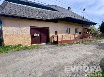 Exteriér rodinného domu s garáží, omítková fasáda, střecha s eternitovými šablonami, klidná venkovská lokalita, prostorná příjezdová cesta. | Prodej - dům/vila, 105 m²
