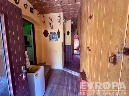 Vstupní chodba se dřevěným obložením, loveckou výzdobou a parketovou podlahou, nabízí rustikální atmosféru a útulné prostředí. | Prodej - dům/vila, 105 m²