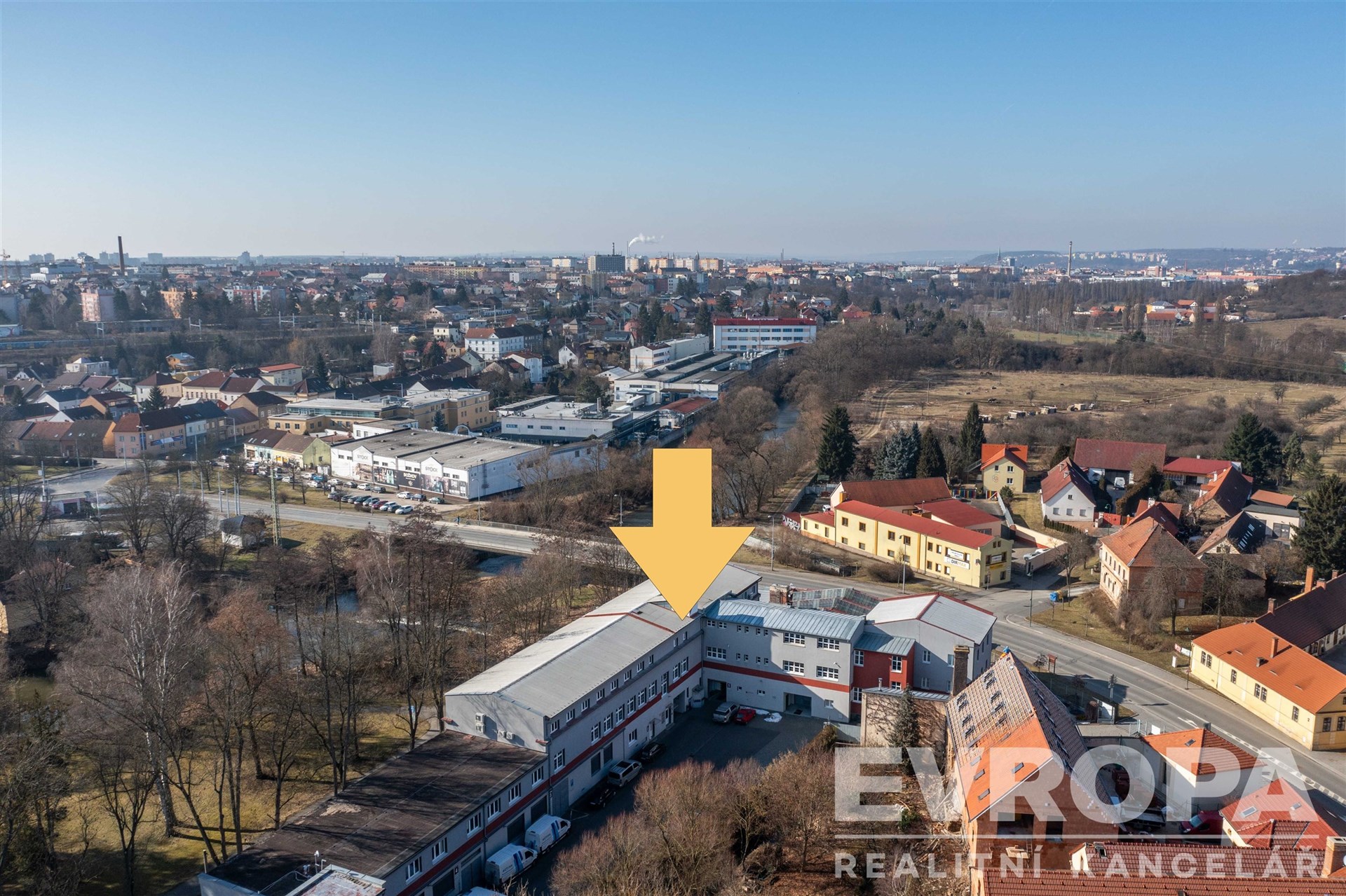 Průmyslová budova s moderní fasádou, nachází se v městské zástavbě, vhodná pro komerční účely, s možností parkování ve dvoře.